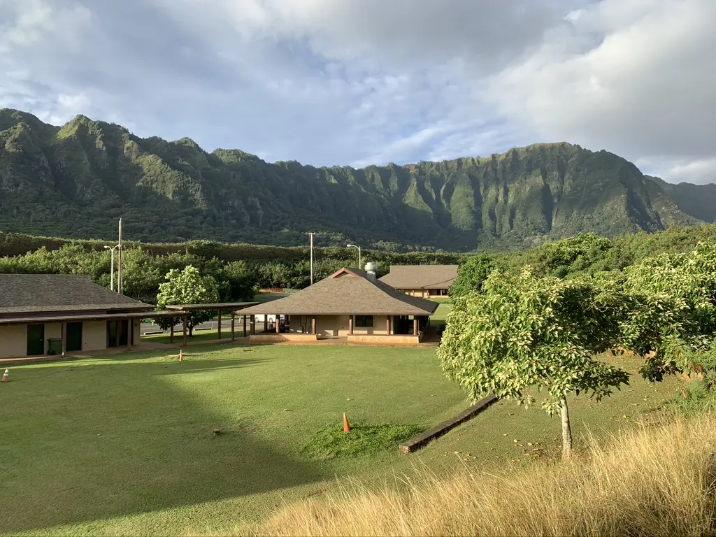 A large grassy field with mountains in the background.